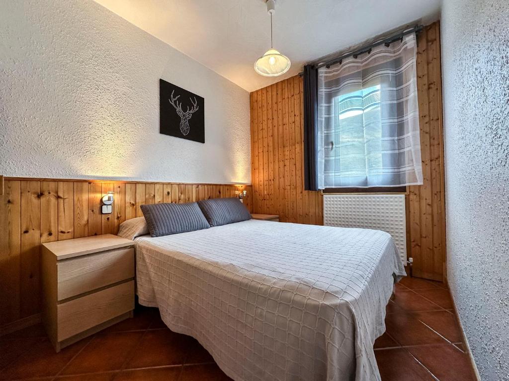 Schlafzimmer mit einem Bett und einem Fenster in der Unterkunft Grizzli Pedrous in Pas de la Casa