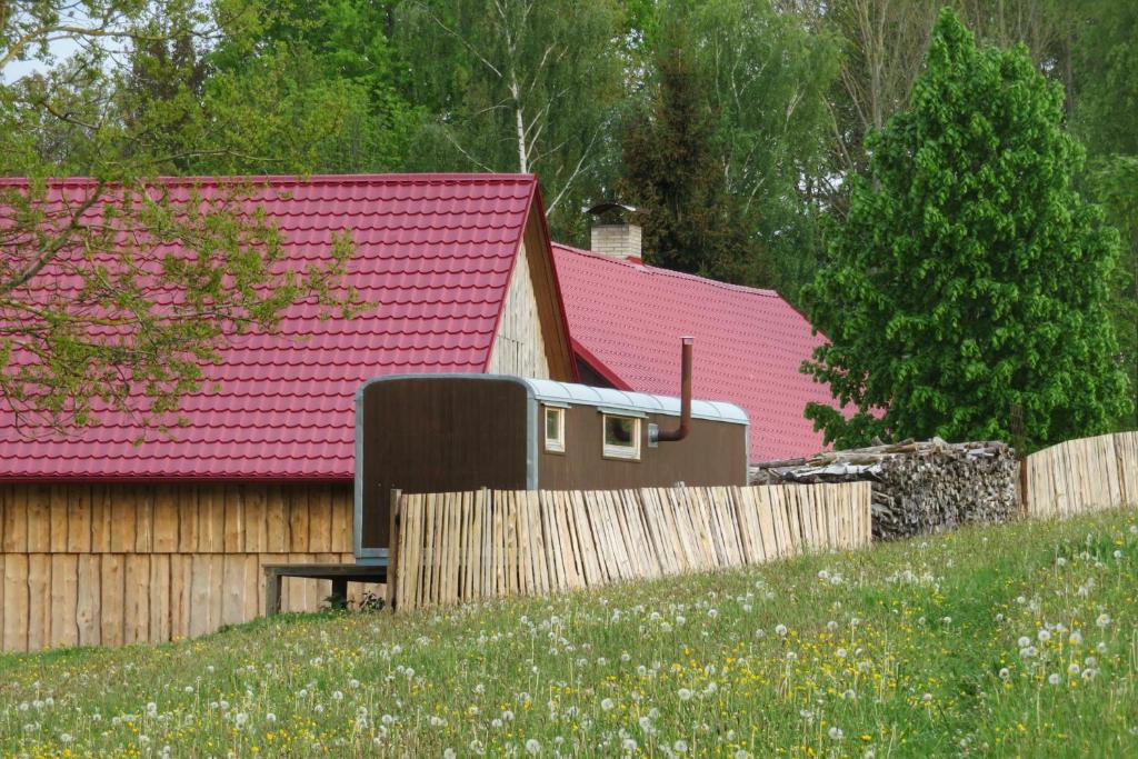una casa con techos rosados y una valla de madera en Maringotka na samotě na kozí farmě en Poběžovice