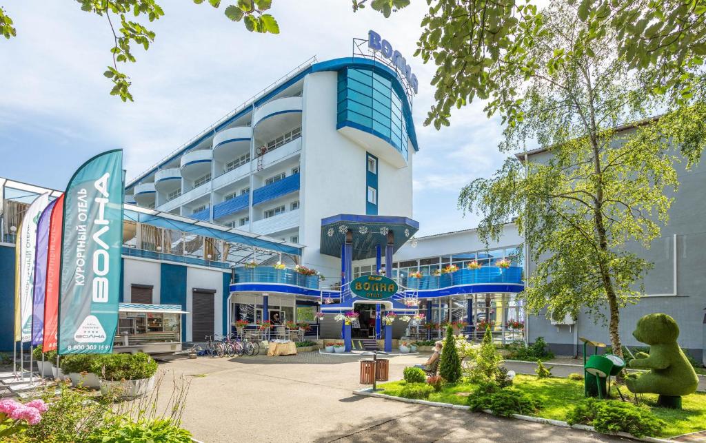 スヴェトロゴルスクにあるVolna Hotelの青い大きな建物で、正面に中庭があります。