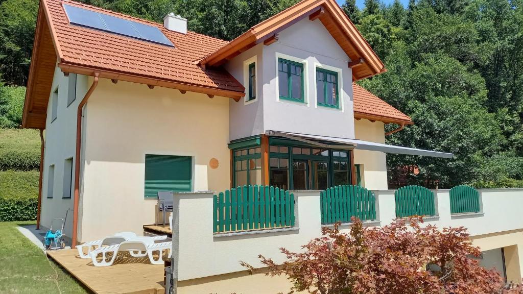 a house with a red roof at Ferienhaus Manuela in Velden am Wörthersee