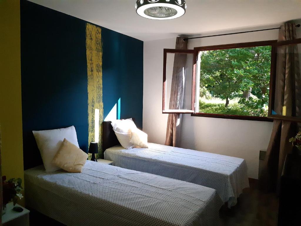 two beds in a room with a window at n6 appartement de Vacancorse Maison U Canale in Speloncato