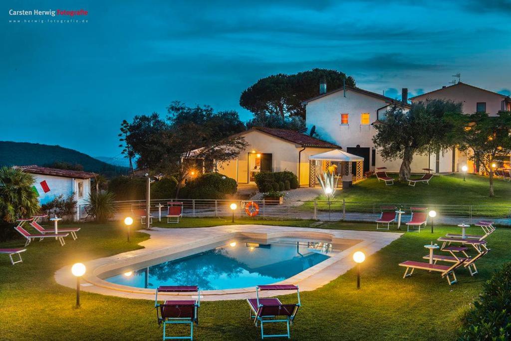 uma casa com piscina à noite em Agriturismo Baia degli Ulivi em Massa Marittima