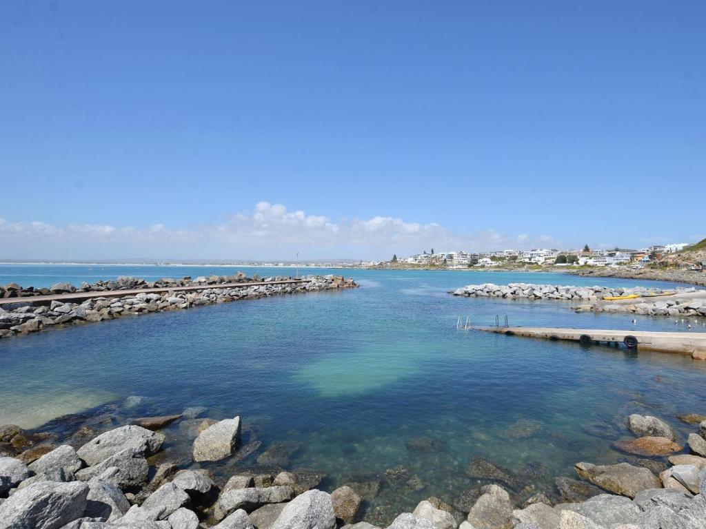 a large body of water with rocks in it at Sea Glimpse Yzer in Yzerfontein