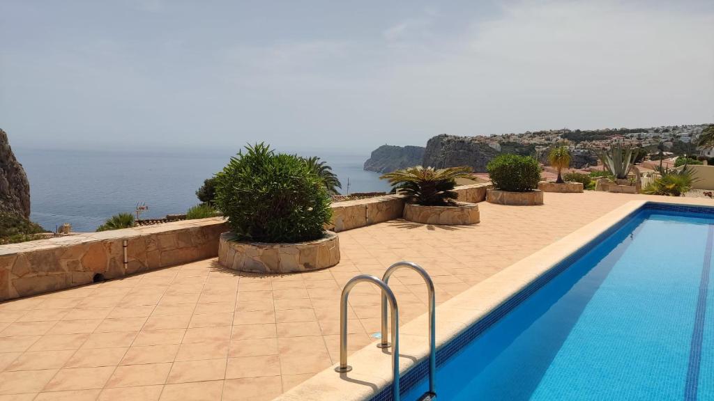 a swimming pool with a view of the water at Cala Moraig in Benitachell