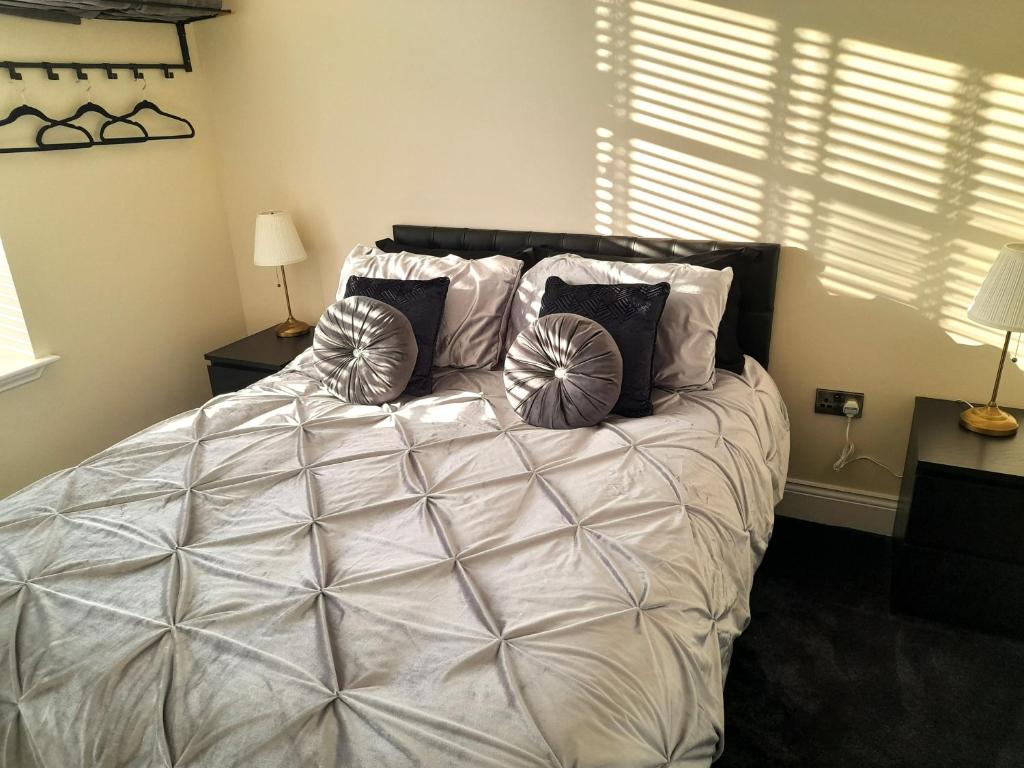 una camera da letto con un grande letto bianco con cuscini di Kirkcudbright Holiday Apartments - Apartment C a Kirkcudbright