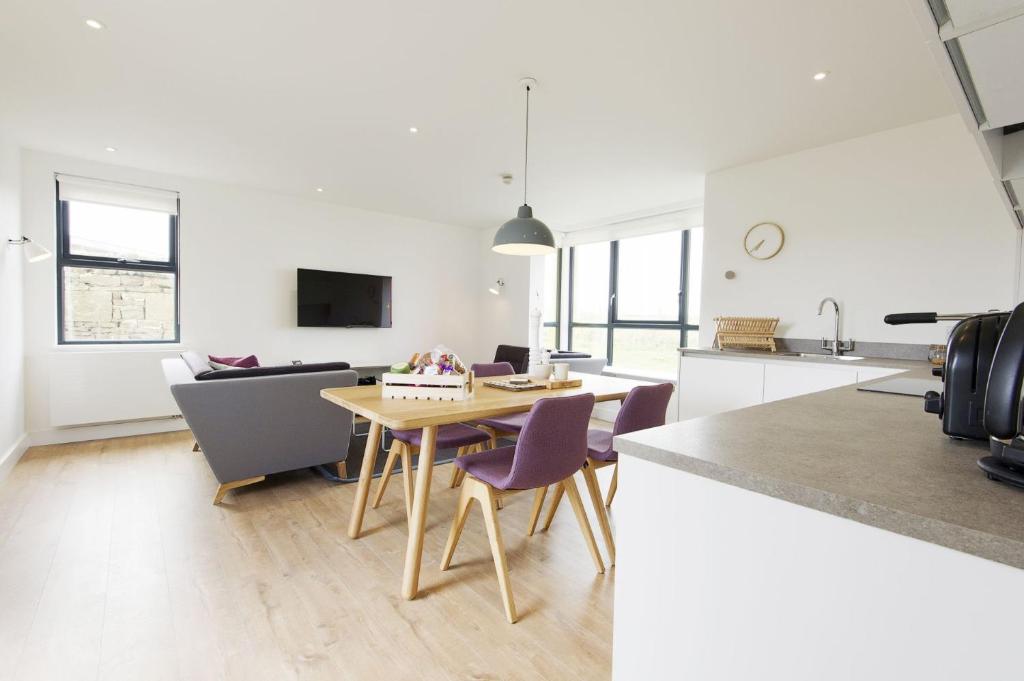 a kitchen and living room with a table and chairs at Buckie - 2 Bed Luxury Apartment in Wick