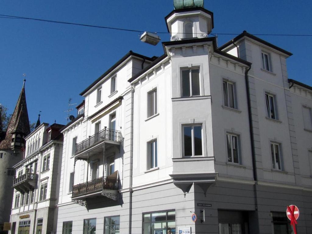Un bâtiment blanc avec une tour d'horloge en haut dans l'établissement Laura, à Äschach