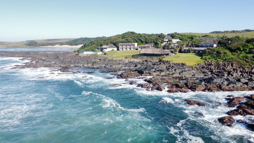 una vista aerea sull'oceano e su una costa rocciosa di Kob Inn Beach Resort a Qora Mouth