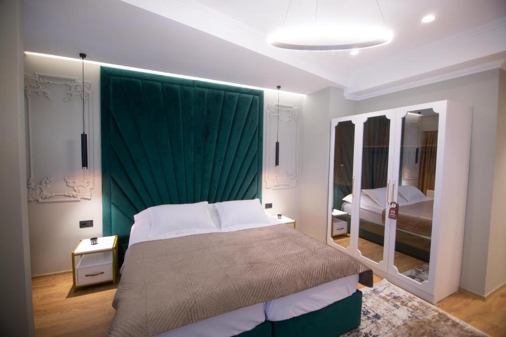 a bedroom with a bed with a green canopy at Sky View Hotel in Korçë