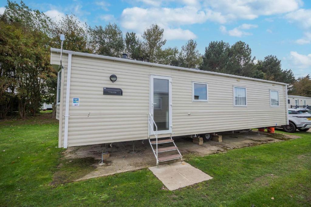 a mobile home with a ladder in a yard at Great 8 Berth Caravan In Norfolk Near To Great Yarmouth Ref 20178bs in Hopton on Sea