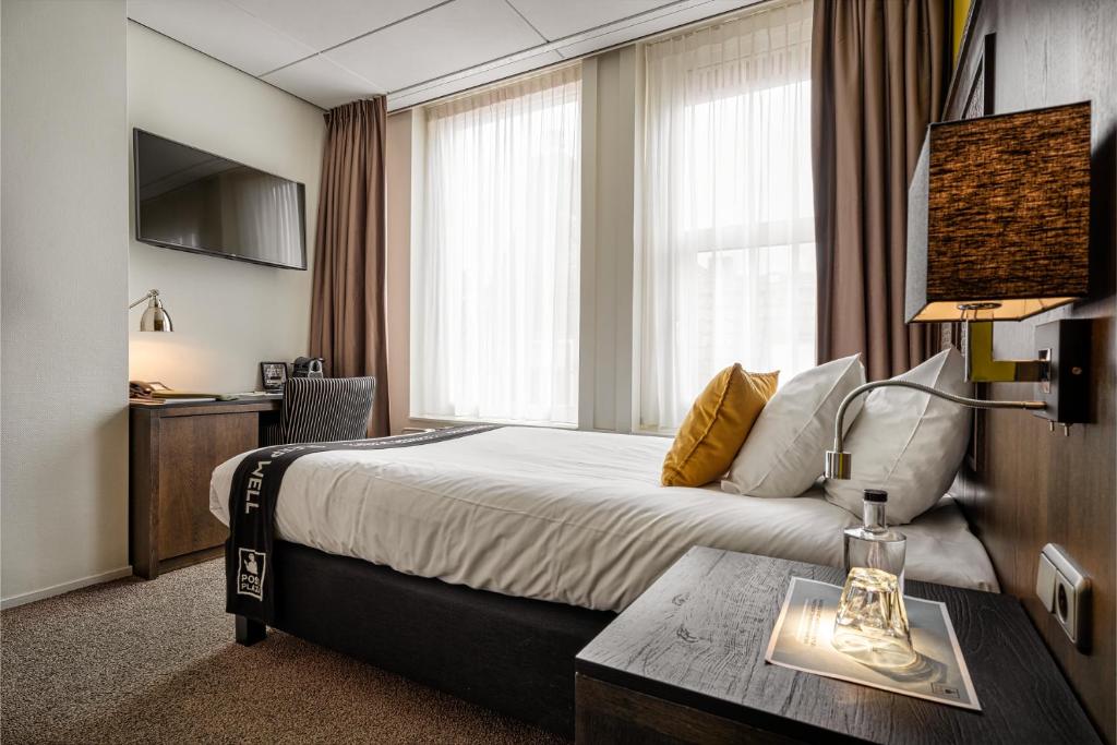 een hotelkamer met een groot bed en een tafel bij Post-Plaza Hotel & Grand Café in Leeuwarden