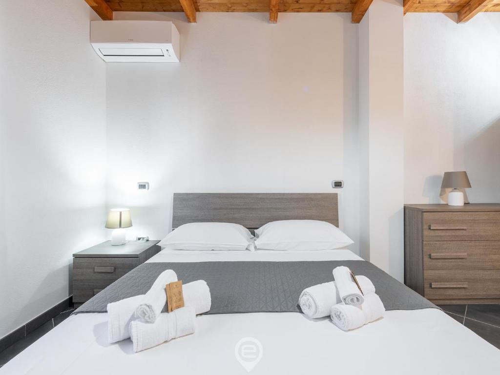 1 dormitorio con 1 cama con toallas en Floris Modern House, en Gonnesa