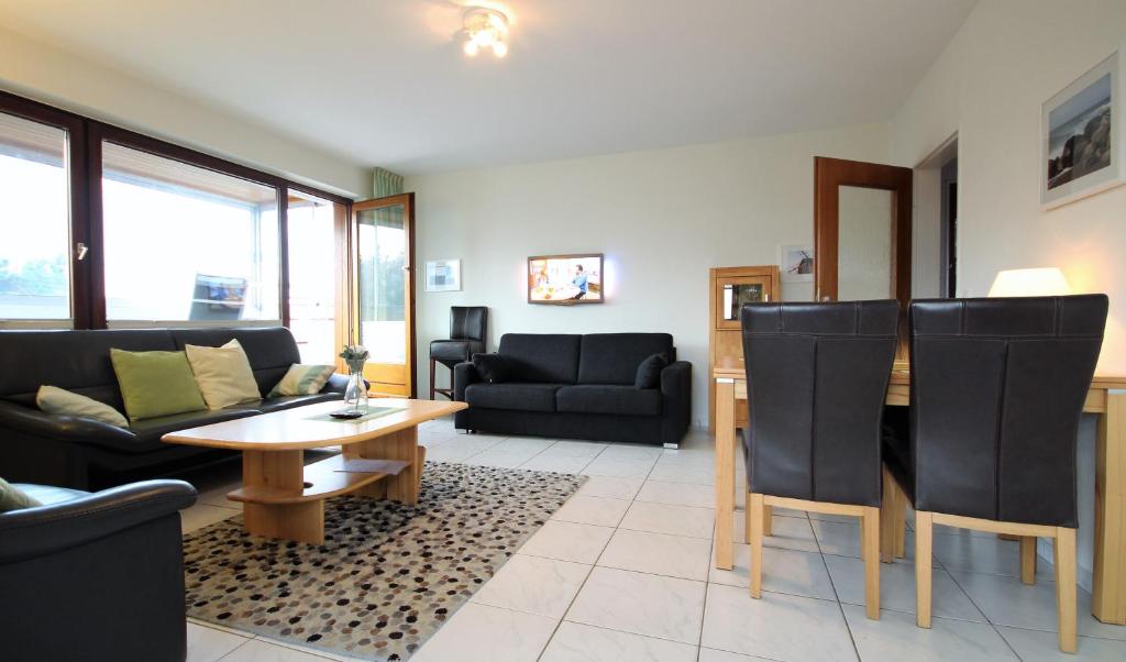 ein Wohnzimmer mit einem Sofa und einem Tisch in der Unterkunft Haus Seehund Wohnung 13 in Cuxhaven