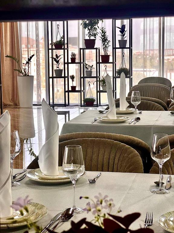 a dining room with tables with white tablecloths and glasses at Mir Luxe Plaza in Tashkent