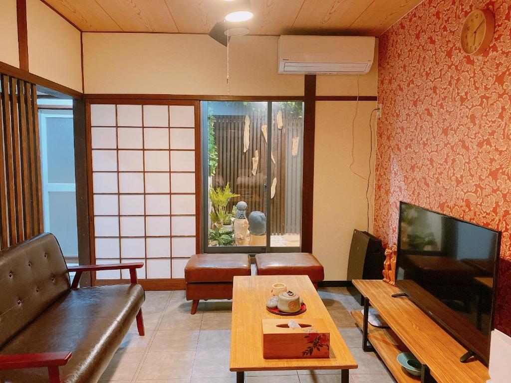 sala de estar con sofá y mesa en 悠雅軒, en Osaka