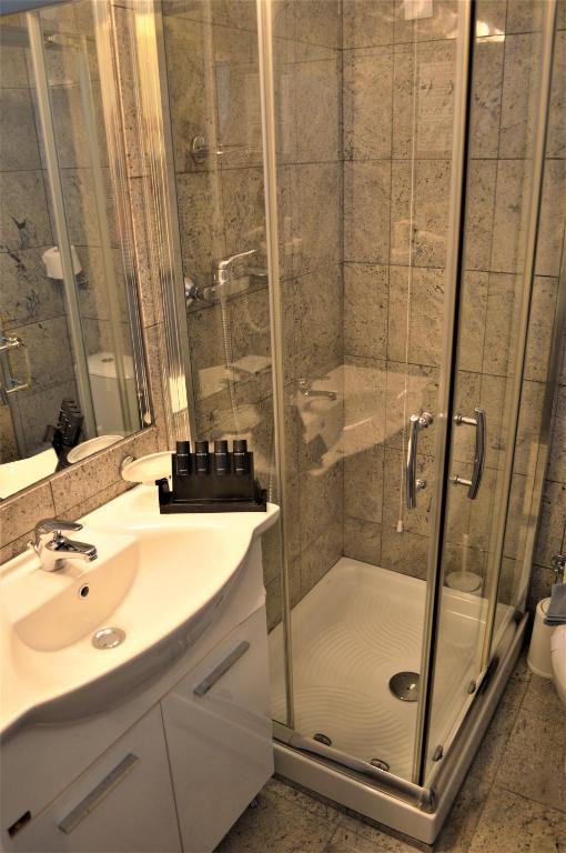 a bathroom with a shower and a sink at Patmos Paradise Hotel in Kámbos