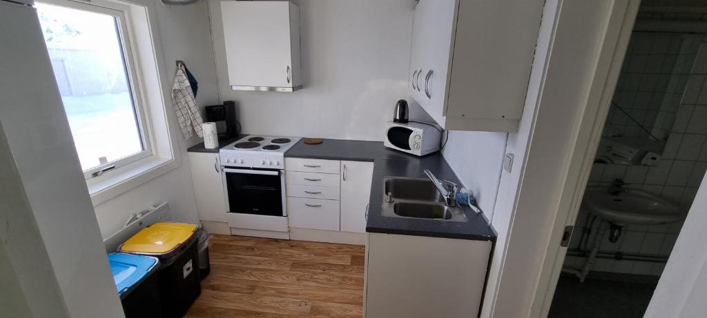 a small kitchen with a sink and a stove at Sleep In in Nordmannset