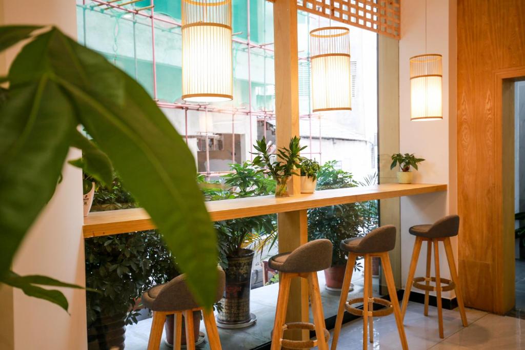 un bar con taburetes en una habitación con plantas en 武陵山水客栈Wuling Shanshui Hotel en Zhangjiajie