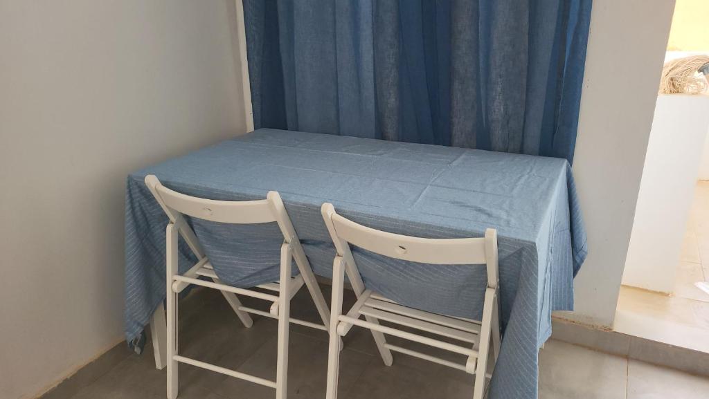 Iknews Appart Dakar في داكار: طاولة مع كرسيين وقطعة قماش من الطاولة الزرقاء