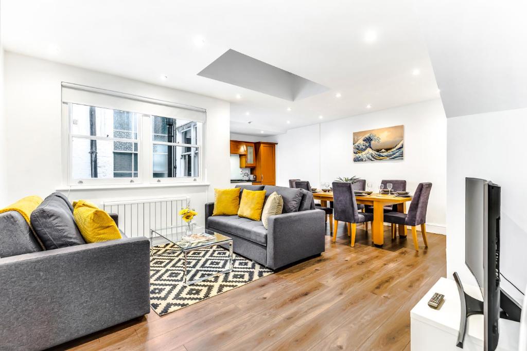 ein Wohnzimmer mit einem Sofa und einem Tisch in der Unterkunft Mews In Marylebone - Prime Central London in London