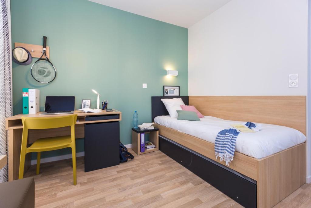 a bedroom with a bed and a desk and a chair at Résidence Odalys Nantes Cité des Congrès in Nantes