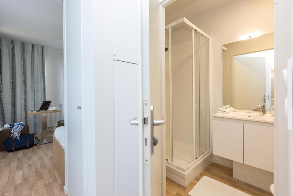 a bathroom with a sink and a mirror at Résidence Odalys Nantes Cité des Congrès in Nantes