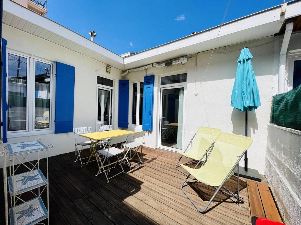 une terrasse avec des chaises, une table et un parasol dans l'établissement Élégante maisonnette à 230m de la plage avec terrasse, clim, WiFi - idéale 5 pers., Arcachon - FR-1-433-100, à Arcachon