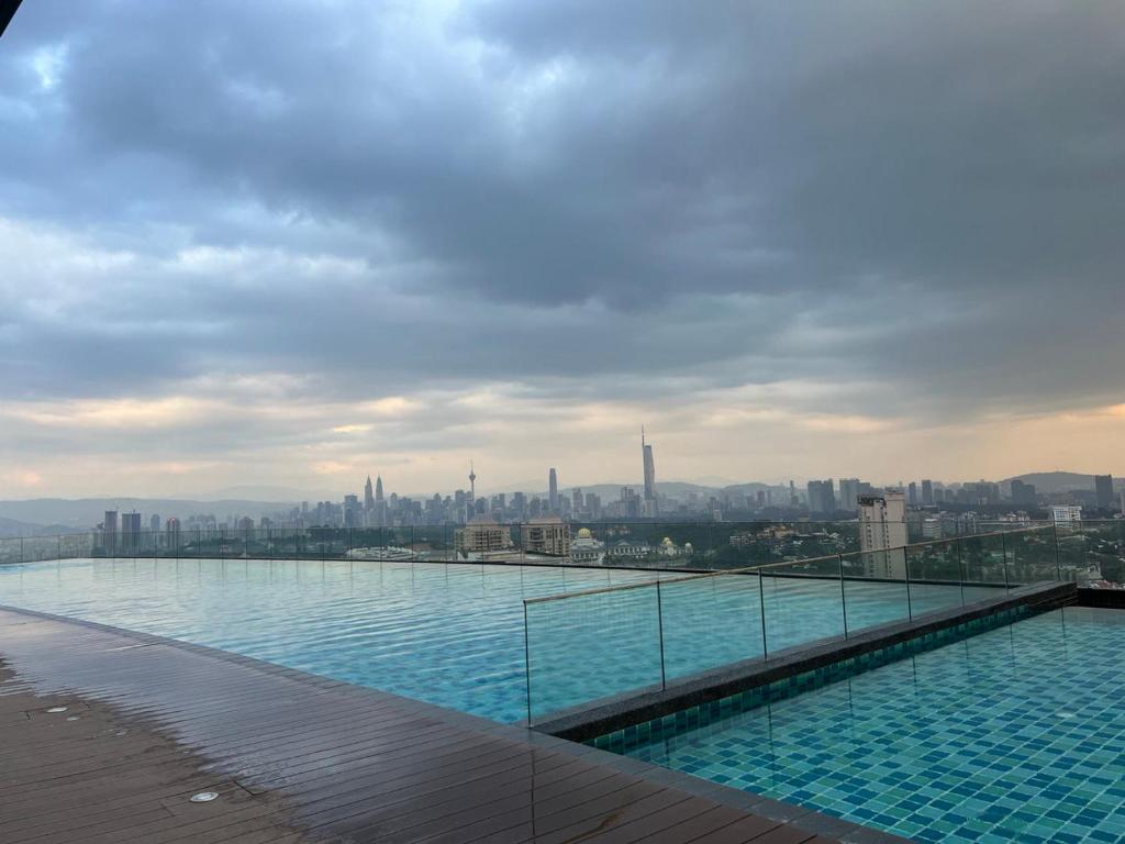 una piscina en la parte superior de un edificio con ciudad en OOAK residence, en Kuala Lumpur