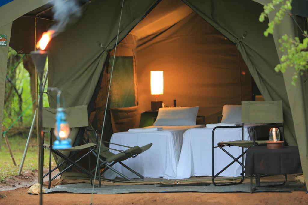 a tent with two beds and chairs in it at Big Game - Yala by Eco Team in Yala