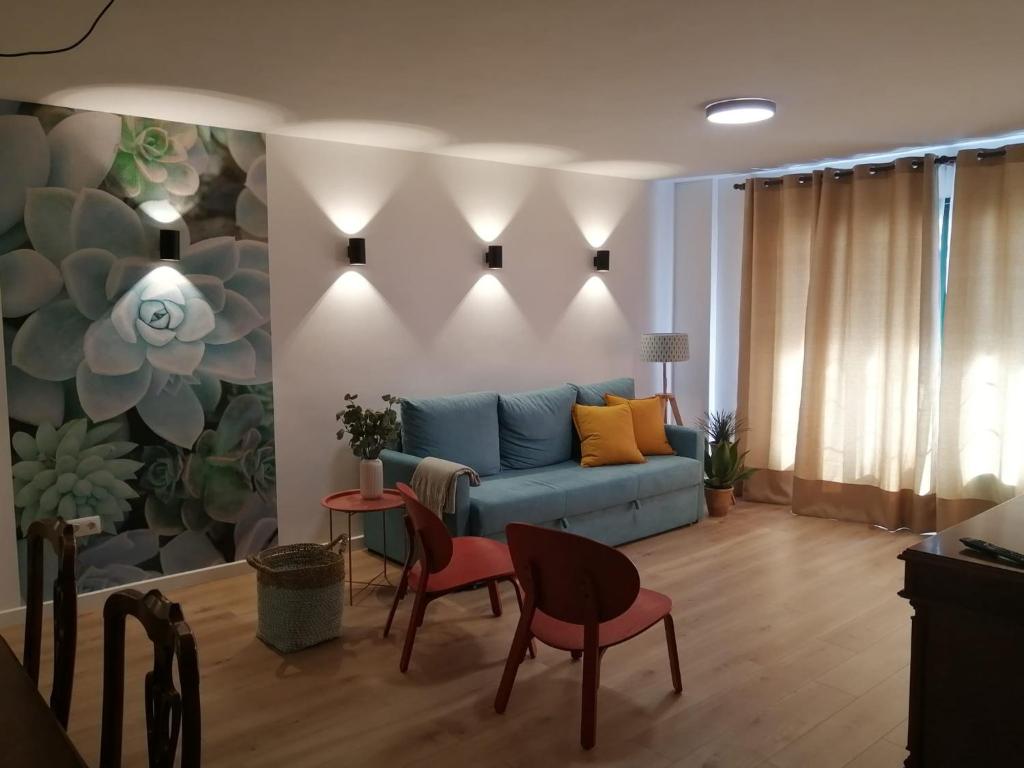 een woonkamer met een blauwe bank en 2 stoelen bij Acogedor apartamento en Puerto de la Cruz in Puerto de la Cruz