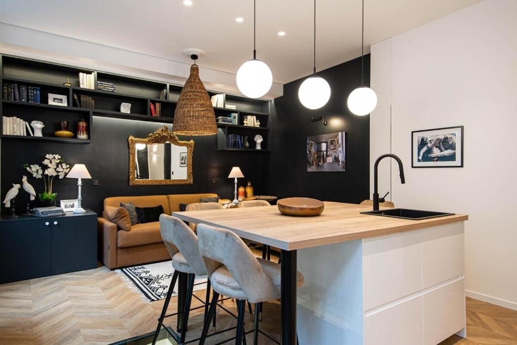 a kitchen and living room with a kitchen island with chairs at La librairie parisienne-Convention, Porte de Versailles in Paris