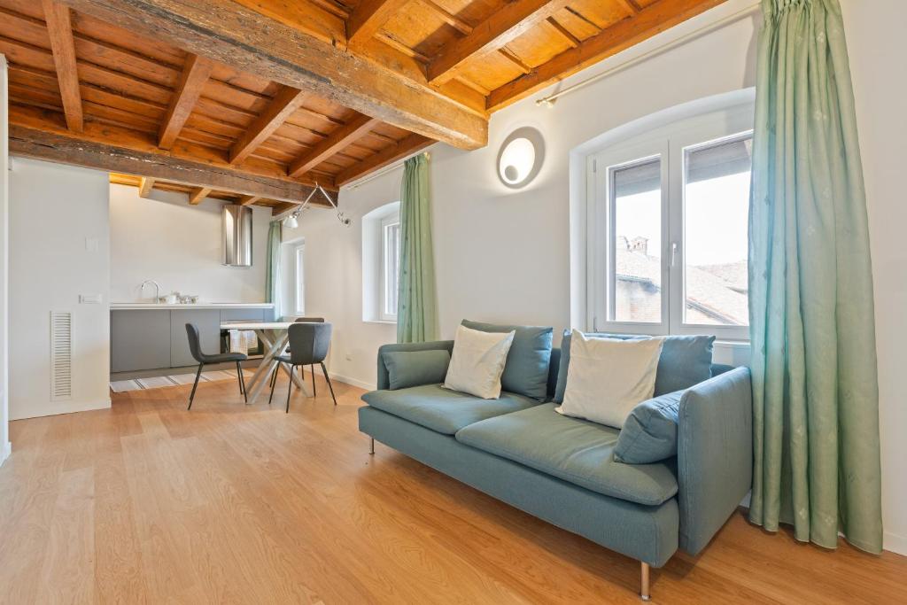 a living room with a blue couch and a table at La Corte Apartment 1 in Peschiera Borromeo