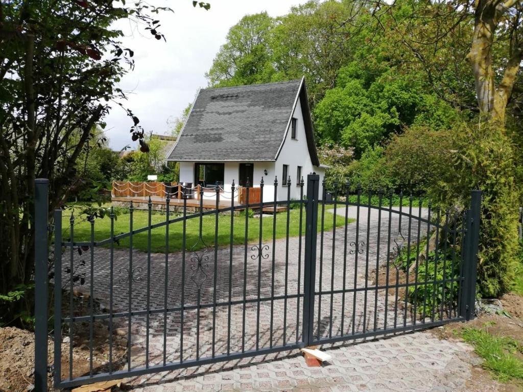 a gate in front of a small white house at Ferienhaus zum Sonnenblick in Kröpelin