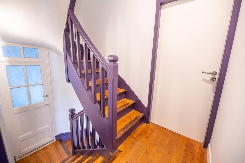a stairway with a purple railing and a door at La Mésange Huppée #8 Gare in Quimper