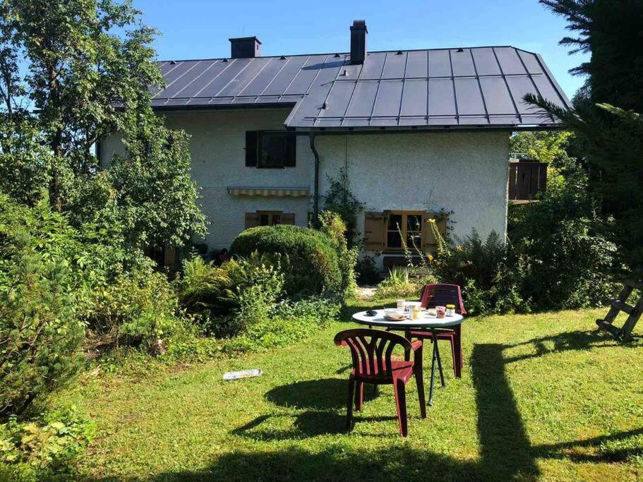 a table and chair in the yard of a house at Auszeitshäusel ideal für Naturfreunde und Wanderer in Marktschellenberg