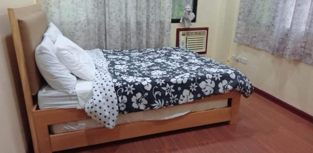 a bedroom with a bed with a black and white comforter at Villa Ceferina Bohol in Tagbilaran City