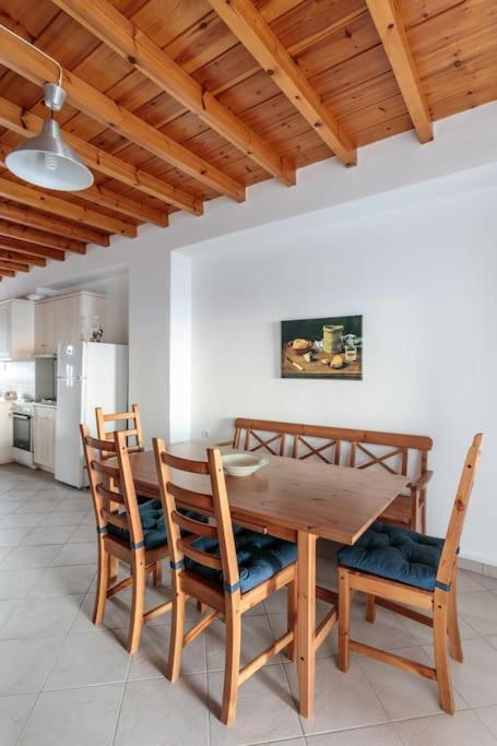 a dining room with a wooden table and chairs at "Triacanthos" 2 bedroom house in Moutsoúna