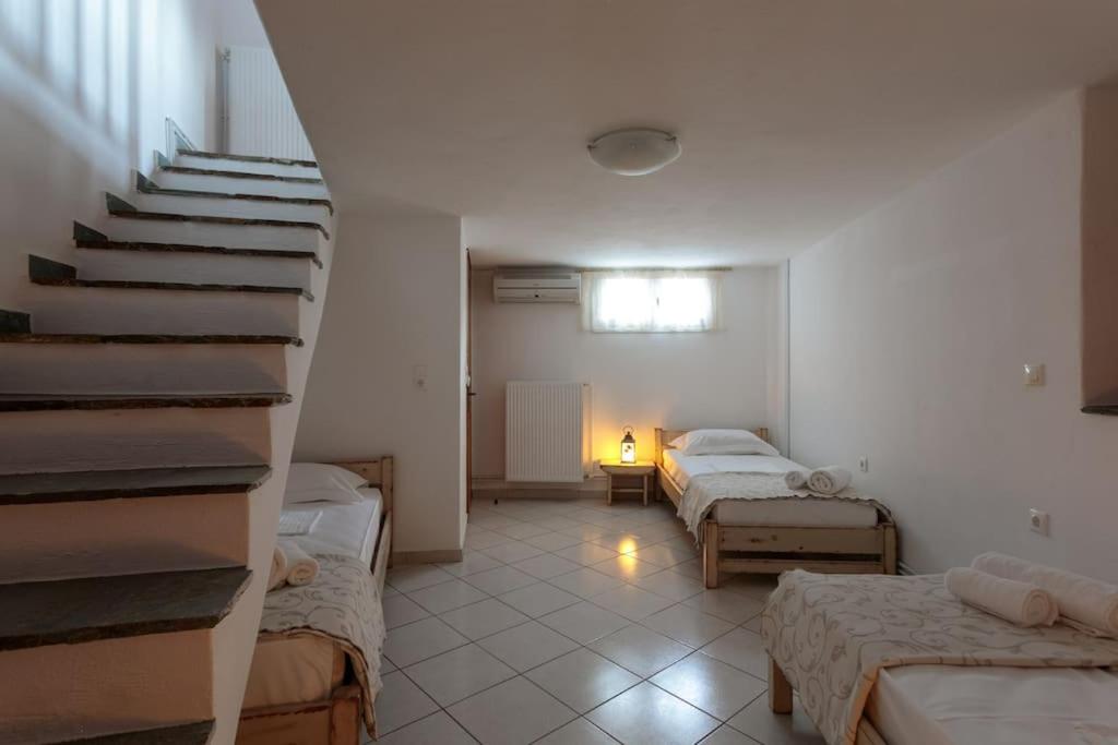 Moutsoúnaにある"Triacanthos" 2 bedroom houseのベッド2台と階段が備わる部屋