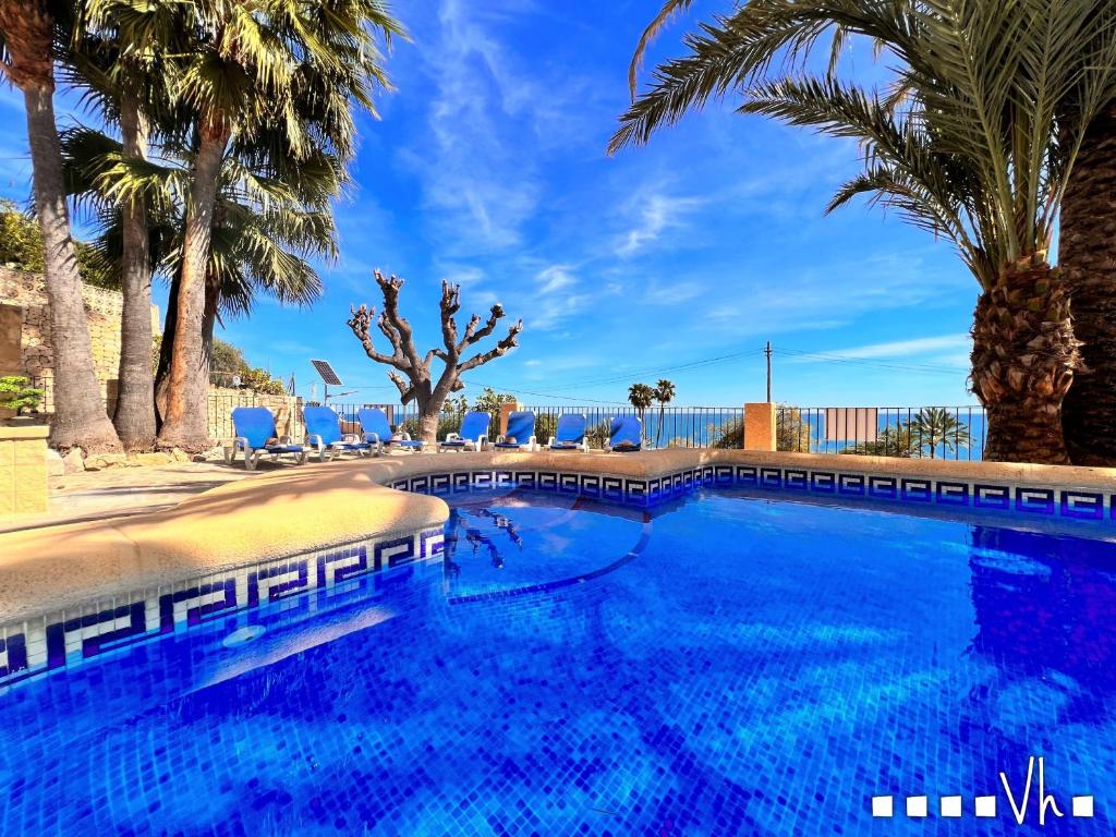 a large swimming pool with palm trees and blue skies at VH CostaBlanca - EVA in Benissa