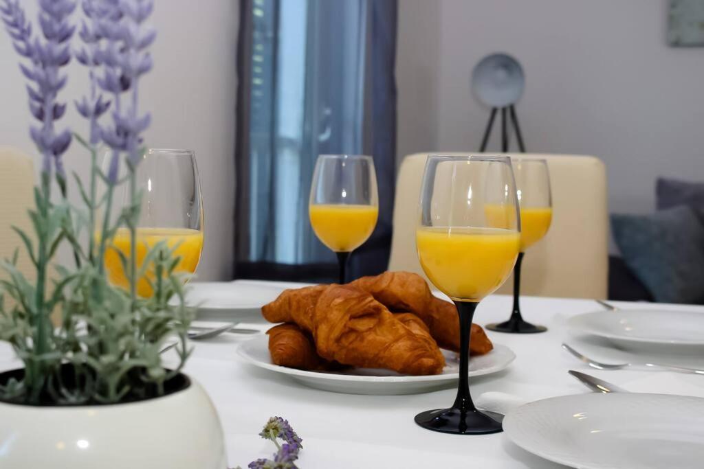 een tafel met 2 glazen sinaasappelsap en croissants bij Agape Apartment in Novi Vinodolski