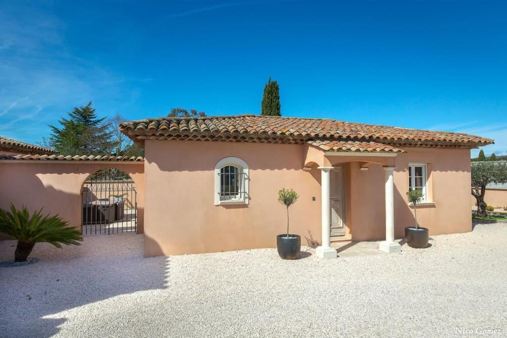 uma pequena casa cor-de-rosa com um portão e vasos de plantas em Roquebrune-sur-Argens, villa 2 pièces, 4 personnes em Roquebrune-sur-Argens