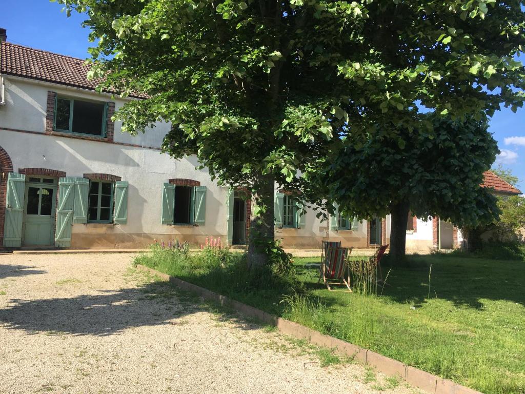 una casa con un albero di fronte di Maison de campagne bourguignonne 19ème entièrement rénovée a Chaumot