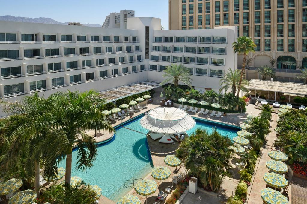 einen Luftblick auf einen Hotelpool mit Palmen und Gebäuden in der Unterkunft Lagoona by Isrotel Collection in Eilat