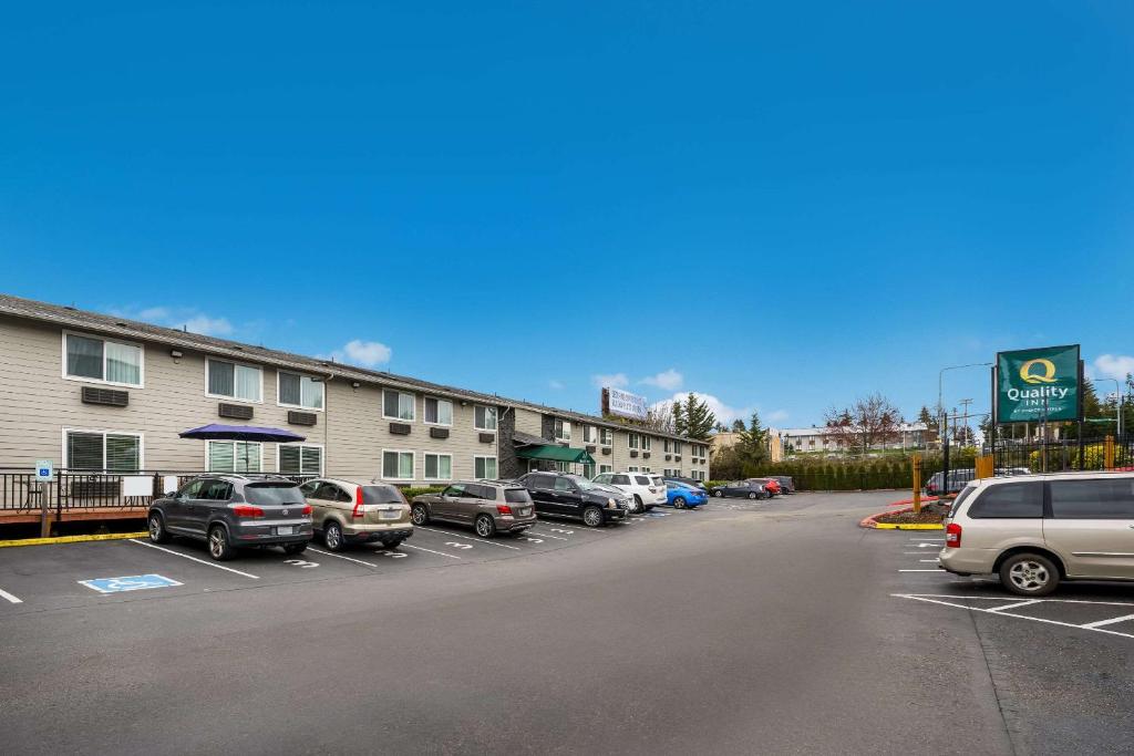 um parque de estacionamento com carros estacionados em frente a um hotel em Quality Inn SeaTac Airport-Seattle em SeaTac