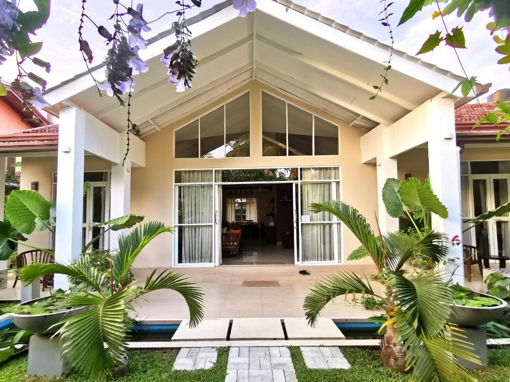 una casa con grandes ventanas y plantas en Casa Mira Boutique Villa, en Mirissa