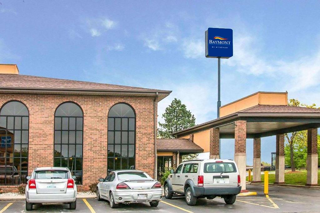 3 voitures garées dans un parking en face d'un walmart dans l'établissement Baymont by Wyndham Flint Airport North, à Flint