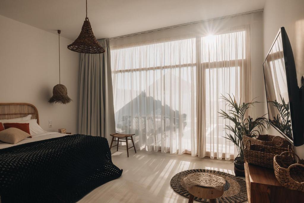 um quarto com uma cama e uma grande janela em Divino Caldera em Akrotírion
