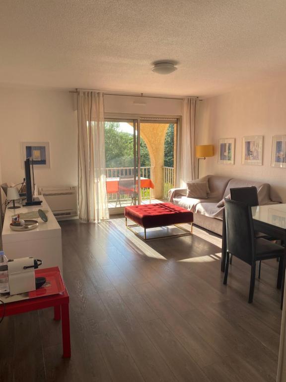 ein Wohnzimmer mit einem Sofa und einem Tisch in der Unterkunft Charmant F2 sur les golfs in Saint-Raphaël