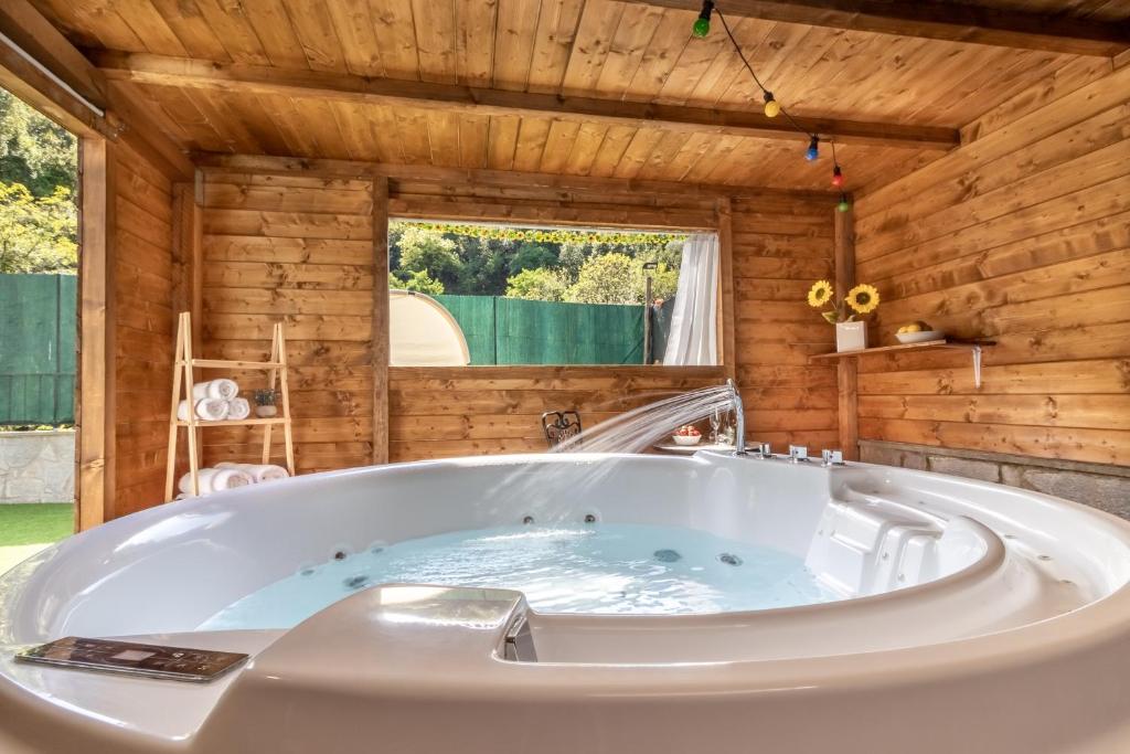 Habitación con bañera grande y paredes de madera. en Luxury Summer House, en La Spezia