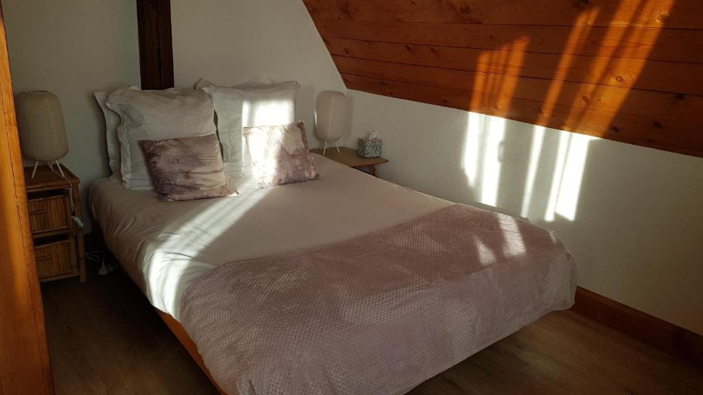 a bedroom with a bed with white sheets and pillows at Studio Marie-Rose in Ribeauvillé